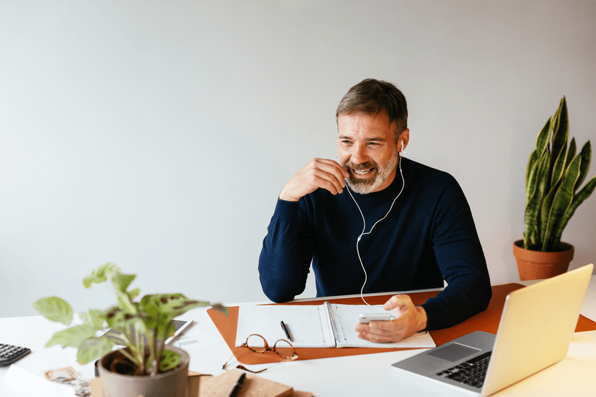 A man taking a phone call at a desk