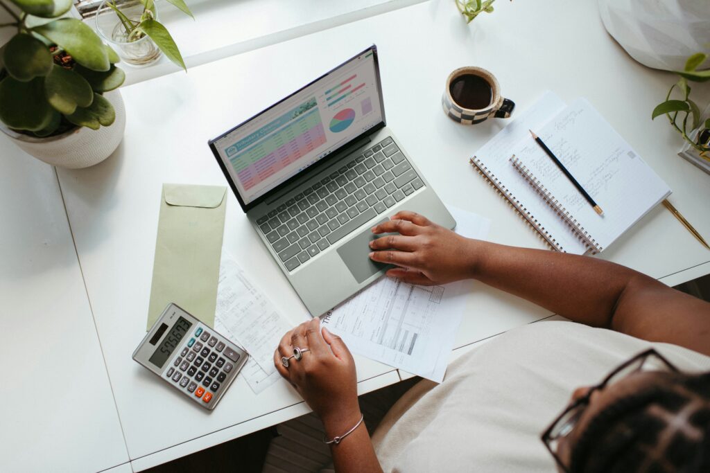 A founder works at a laptop in a bright, modern setting, representing the strategic planning involved in leveraging Qualified Small Business Stock (QSBS) to minimize capital gains taxes in 2025.