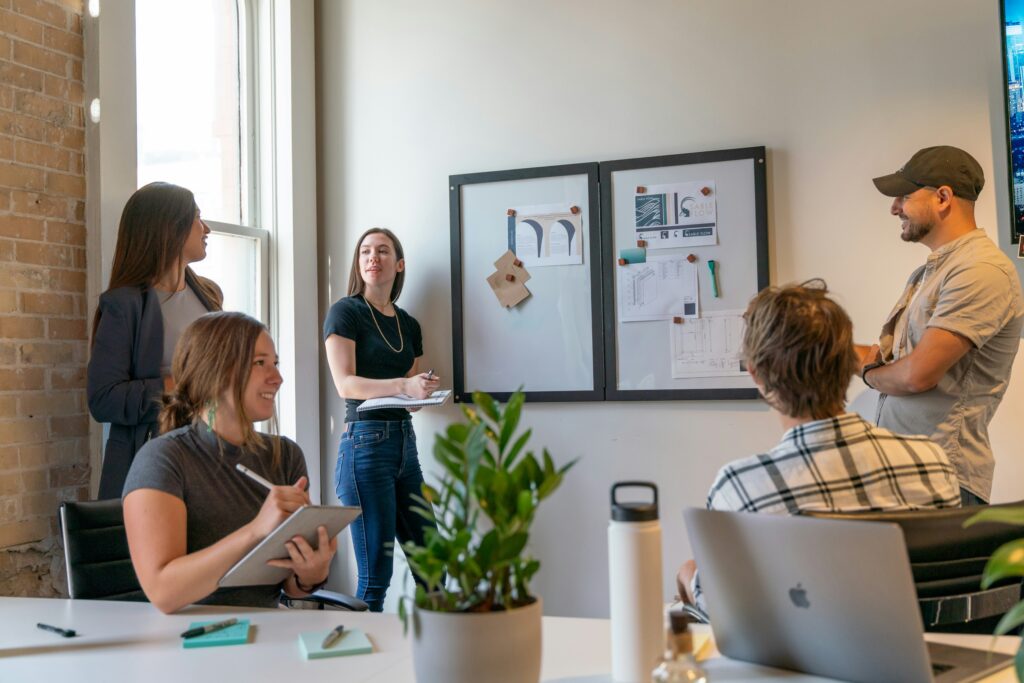 A team gathers around a conference table, actively engaged in discussion. The image represents collaborative financial planning—such as implementing deferred compensation plans—to support founders and key employees in achieving long-term tax advantages