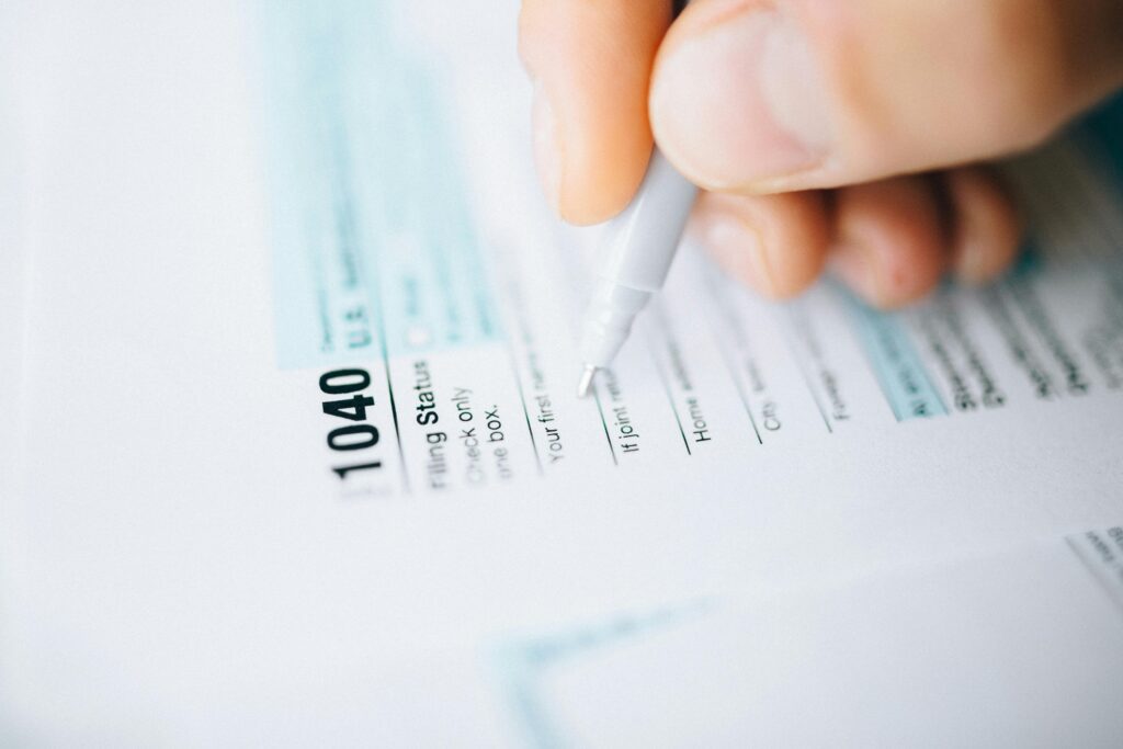 A close-up of a pen and tax forms with handwritten notes—symbolizing the importance of tracking IRS deadlines for quarterly estimated tax payments.