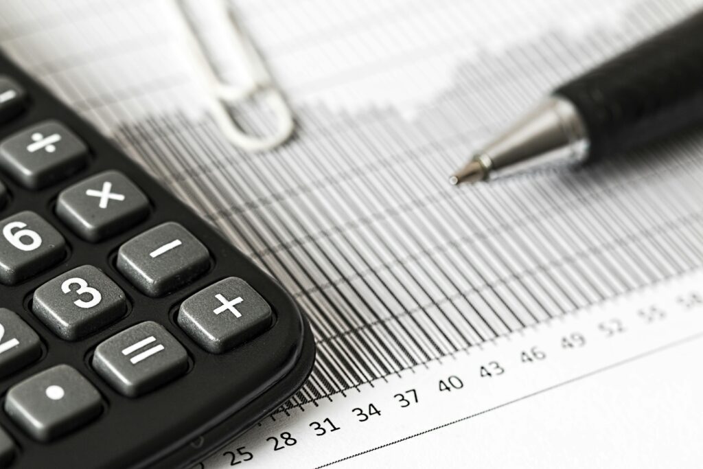 A calculator and pen resting on financial paperwork—representing the calculations expats must make to determine Foreign Earned Income Exclusion eligibility and avoid double taxation.