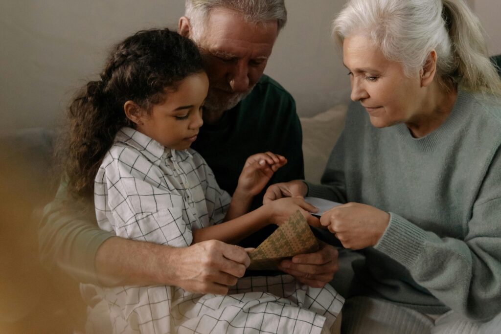 Grandparents crafting with their granddaughter at home—representing legacy planning and the importance of utilizing estate tax exemption portability to protect wealth for future generations.