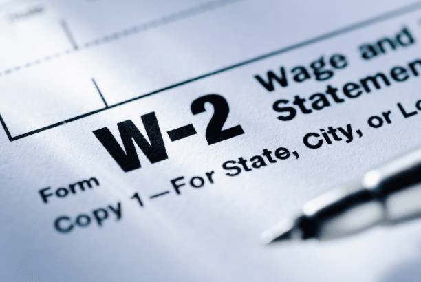 Close-up of a W-2 tax form with a pen resting on it—illustrating the importance of reviewing Box 12 codes for accurate income reporting and tax planning.