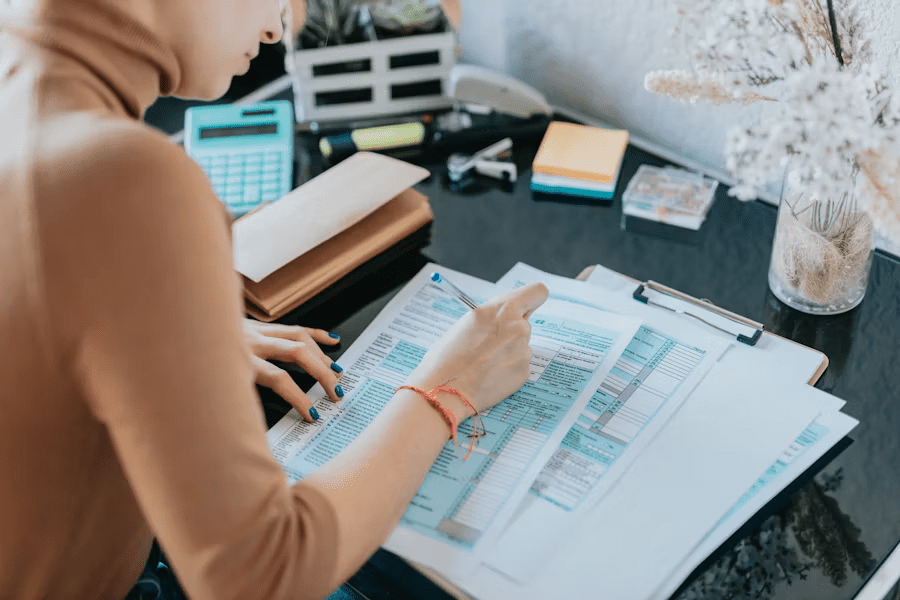 A woman focused on completing a tax form at her desk—illustrating the hands-on effort many small business owners must make when filing excise taxes with Form 720.