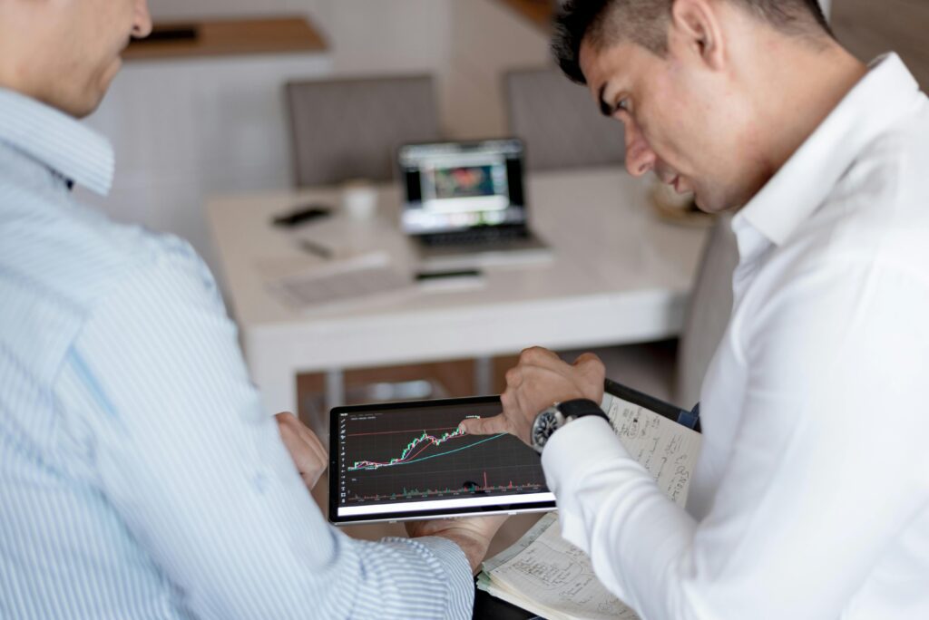 A man in a white long-sleeve shirt is holding a black digital tablet, symbolizing the concept of capital loss carryforward rules.
