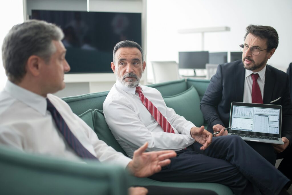 Financial advisor presenting an evergreen private equity fund strategy on a whiteboard during an investment meeting.