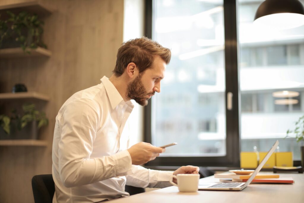 A man in a white dress shirt stands confidently, representing the comparison between SEP IRAs and Solo 401(k) plans in 2025.