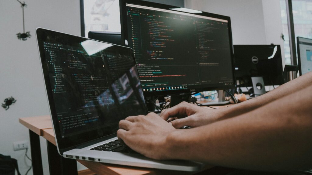 Person working on a computer with data charts visible on the screen.