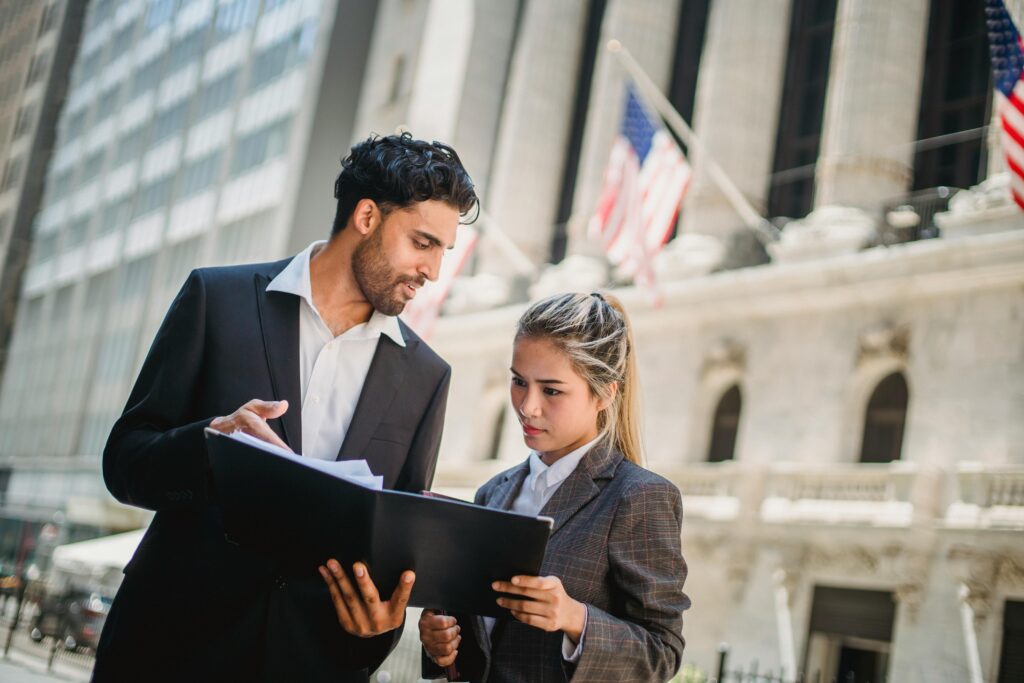 A man and woman in formal attire reviewing trade documents, representing the 2025 de minimis exemption changes and new import compliance landscape.