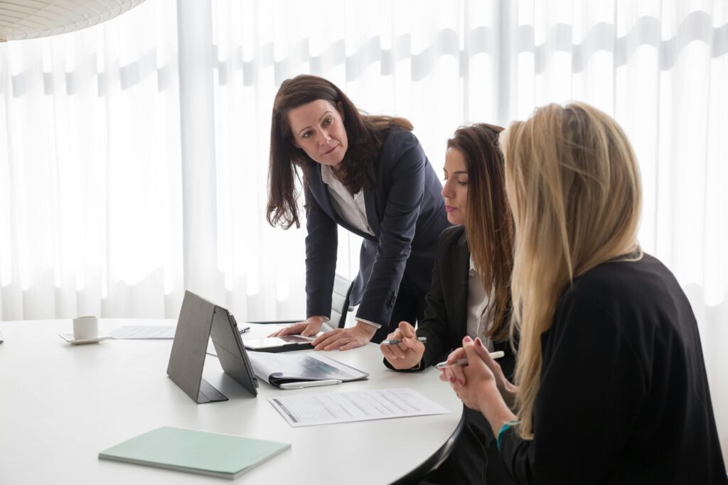 Two women in blazers collaborating in an office, symbolizing professional tax advisors providing personalized Treasury bill tax guidance.