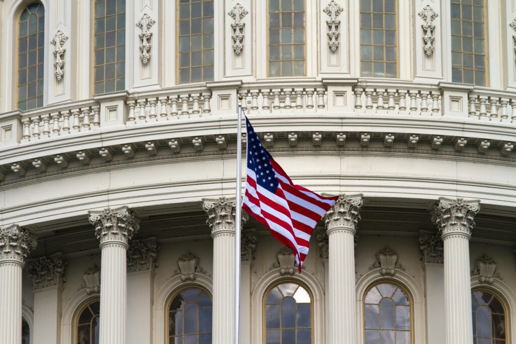 American flag waving in front of a government building, symbolizing U.S. expat tax policy.