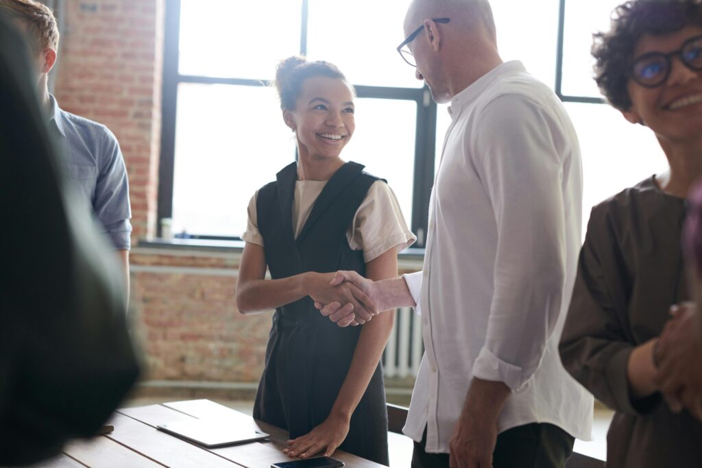A man and woman shaking hands, symbolizing improved client satisfaction.