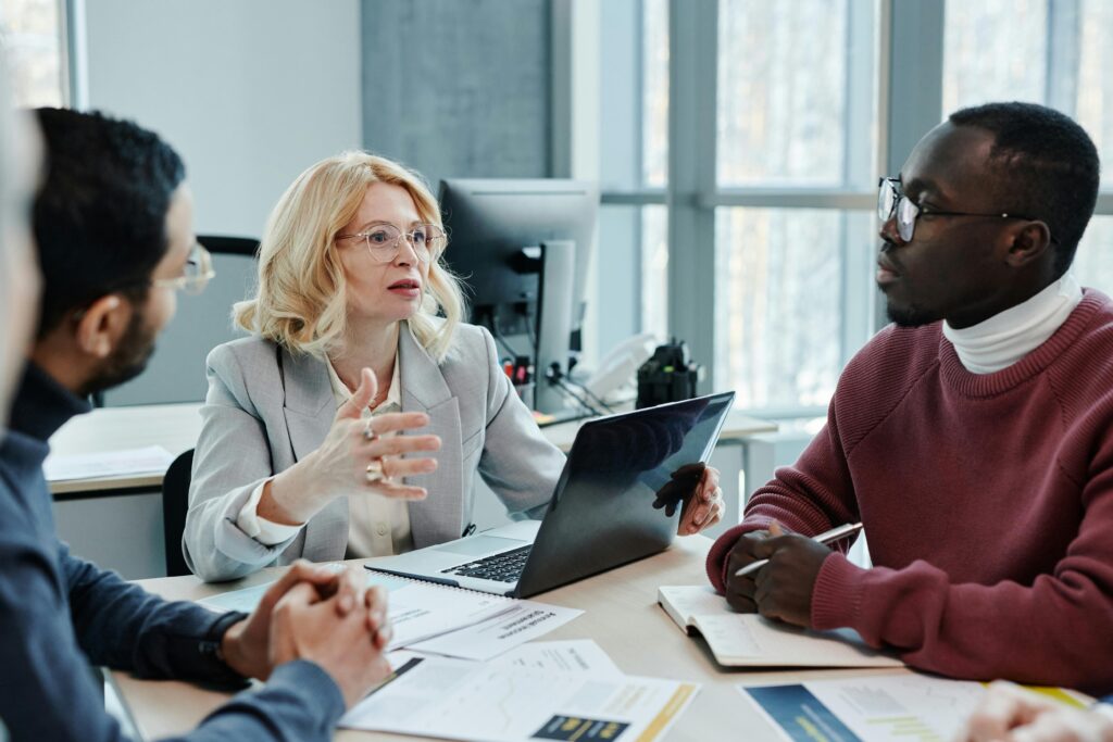 A group of professionals engaged in conversation at a conference table.